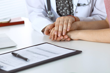 Close-up of doctor  reassuring her female patient. Medical ethics and trust concept