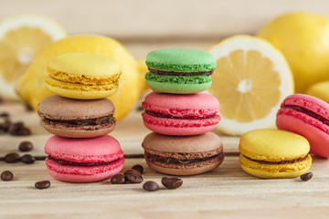 Obraz na płótnie Canvas Green, pink, yellow and brown french macarons with lemon and coffee beans