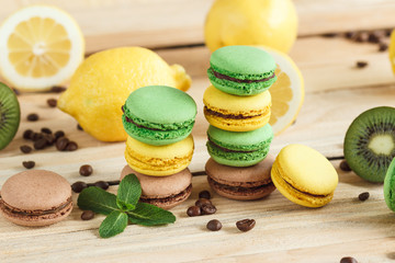 Green, yellow and brown macarons with kiwi coffee beans and mint decorations