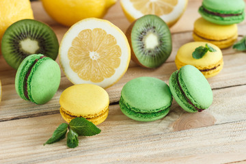 Green and yellow macarons with kiwi, lemon and mint decorations