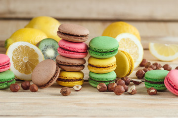 Green, pink, yellow and brown macarons with lemon, kiwi and hazelnuts