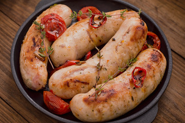 Grilled sausages in frying pan. Wooden background. Top view. Close-up