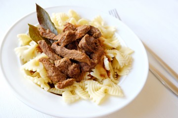 Pasta with beef in tomato sauce and laurel leaf spices 