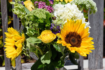 Yellow rose in middle of outdoor arrangement