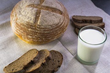 Background food ingredients on the tablecloth. Homemade bread and milk.