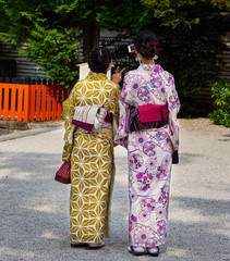 Japanese women in kimono posing together with a cell phone for a selfie