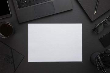 Blank Paper With Laptop And Office Supplies On Gray Desk
