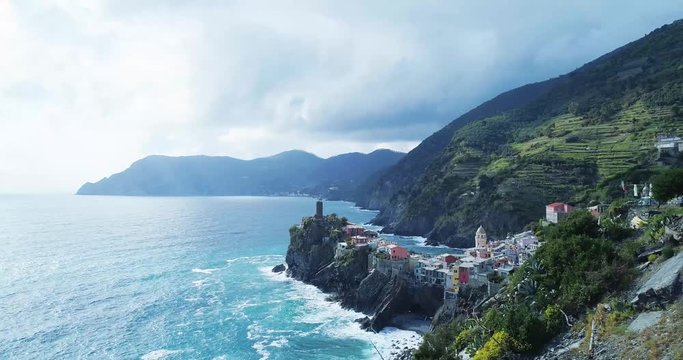 aerial view of travel landmark destination Vernazza, a small mediterranean sea town, Cinque terre National Park, Liguria, Italy. Afternoon sunny and cloud weather. 4k aerial drone side video shot
