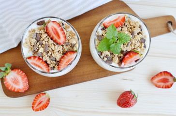Chocolate muesli with yogurt and strawberries, healthy breakfast