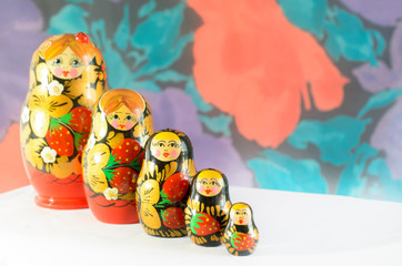 Fototapeta na wymiar Russian matryoshkas on a light background and a colored background.
