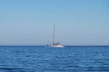 Catamaran navigating along the coast in Portinho da Arrabida, Portugal; Concept for travel in Portugal