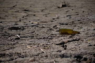 trash bottle on dry cracked ground