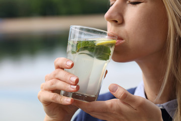 Happy Woman Drinking Summer Refreshing detox Water or Lemonade. Healthy Lifestyle