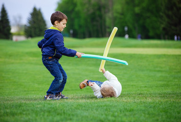 Preschool boys fighting with toy swords