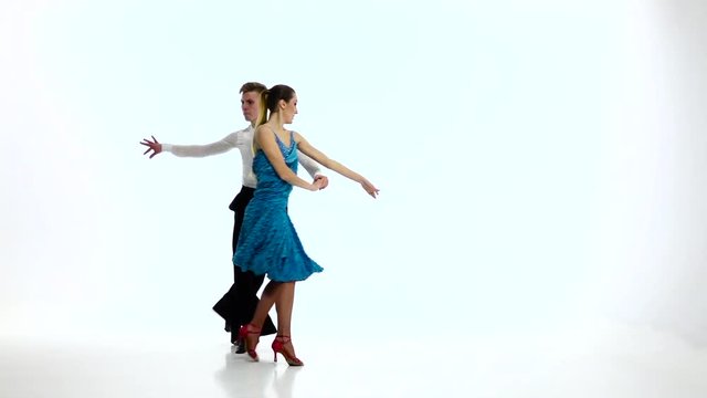 Couple of champions dancers perform latino, slow motion. White studio