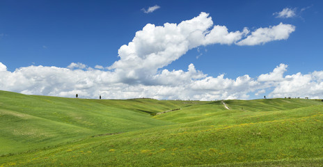 real tuscany landscape with green hills and clouds in the blue sky