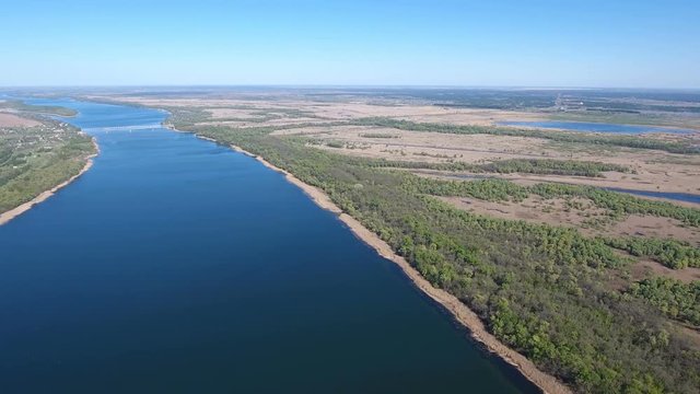 Fabulous aerial shot of the Dnipro river basin with sparkling waters, indented coastline, straw looking cane, islets, lakes, patches of greenary, and amazing skyscape in Ukraine