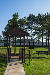 Community on-site dog park at the grassy backyard of a typical apartment complex building in suburban area at Humble, Texas, US. Off-leash dog park with pet stations, toys and bag dispensers