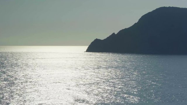 view of ocean mediterranean sea on rocky shore beach coast, near travel landmark destination Cinque terre National Park, Liguria,Italy. Sunset weather reflections. 4k top view drone side video shot