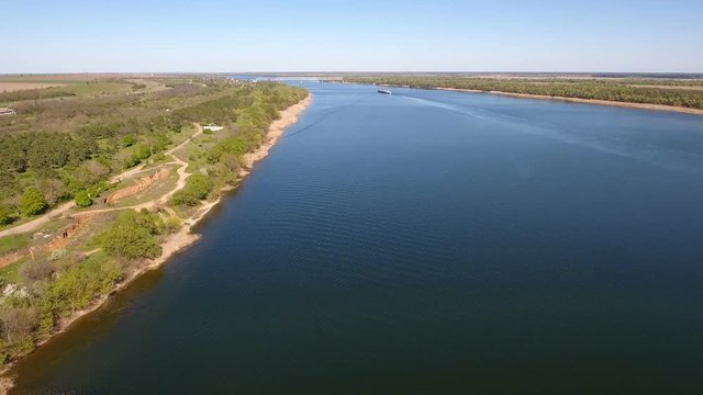 Marvelous aerial shot of the Dnipro river with its bright blue waters, indented coastline, straw looking cane, patches of greenary, and superb skyscape in Ukraine in a sunny day in spring