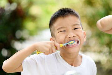 Boy brushing teeth in the garden