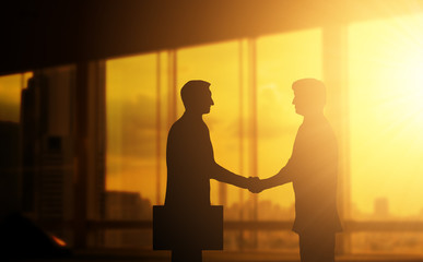 Second hand business hand in concept office silhouettes and successful business partner.