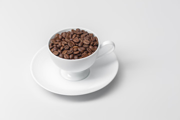 Coffee cup filled with coffee beans 