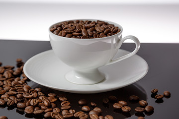 Coffee cup filled with coffee beans 
