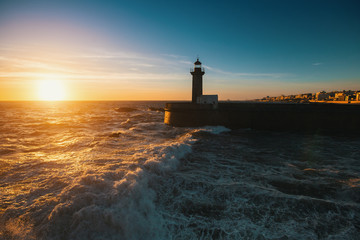 Fototapeta na wymiar Beautiful sunset on the ocean lighthouse at coast of Portugal.