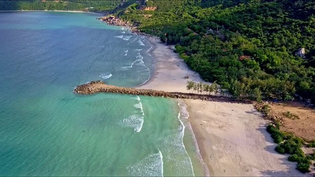 Flycam Moves from Azure Ocean to Sand Beach with Pier