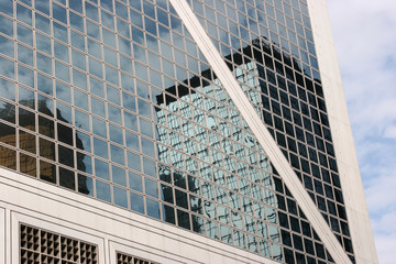 Reflections of modern commercial buildings on a glass wall