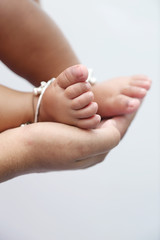 Mother holds baby feet in hands.