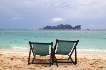 Travel to island Phi Phi, Thailand. Two chairs on a beach near to sea.