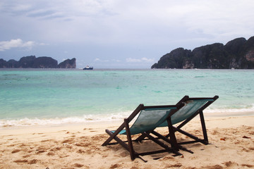 Travel to island Phi Phi, Thailand. Two chairs on a beach near to sea.