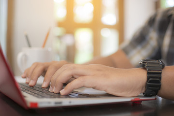 Asian Hipster Business man using laptop computer. Male hand typing for work on laptop keyboard.