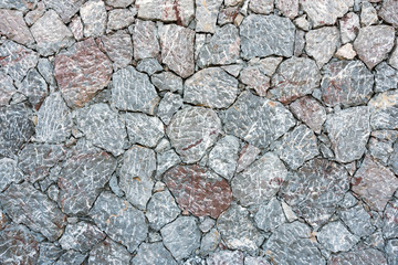 Background from a rough gray natural stone wall