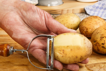 female chef is peeling potatoes