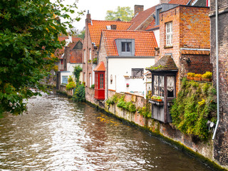 Fototapeta na wymiar Old brick houses along water canals in Bruges, Belgium.