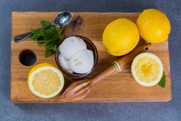 Lemon ice cream sorbet served for dessert with mint leaves and lemons