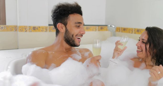 Young Couple In Bath Together Drink Champagne Talking, Man And Woman Lover Enjoy Spa At Home Slow Motion 60