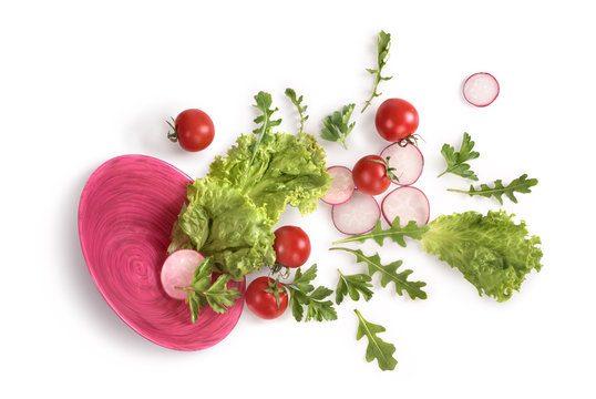 Vegetables in a pink plate on a white background