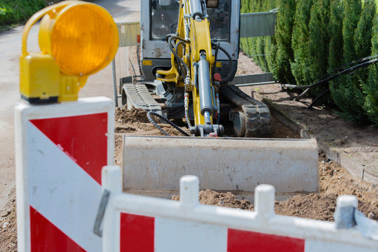 Mini Bagger bei Stra&szlig;enarbeiten 