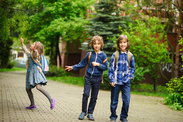 Three little friends hurry on lessons in school.