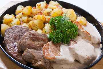 different kind of meat with potatoes on a grill pan