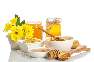 Yellow flowers and bee products (honey, pollen) isolated on white background