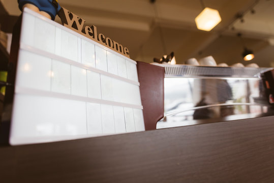 Blank screen welcome sign in the coffee shop in selective focus.