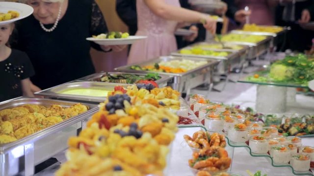 Restaurant guests select food from a buffet.