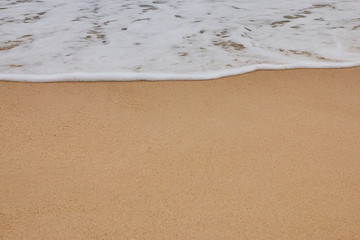 Soft wave of blue ocean on sandy beach. Background.