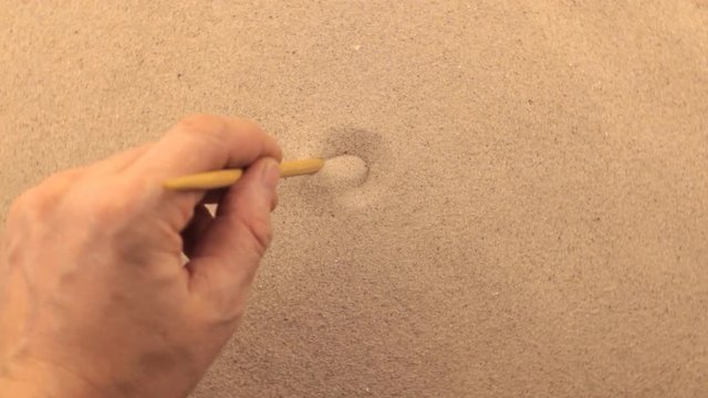 Hand drawing on a rotating sand, spiral.