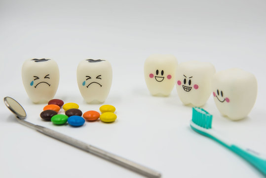 Model Cute toys teeth and colorful candy in dentistry on a white background.